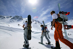 Three Snowboarder on feet, starting their ascend to Koenigsspitze near Ortler, Sulden, Italy