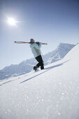 Woman going with skis uphill, Kuehtai, Skifahrerin, Hohe Mut und Gaiskogel im Hintergrund, Kuehtai, Tyrol, Austria