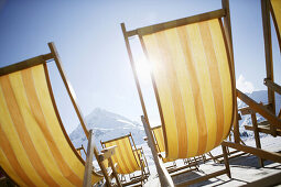 Empty deck chairs, view to snow covered mountains, Kuhtai, Tyrol, Austria