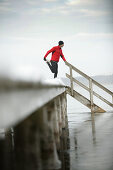 Young man stretching at jetty