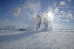 Young couple walking through powder snow
