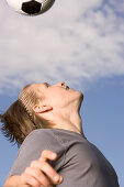 Young soccer player exercising headers