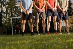 Soccer players awaiting a free kick, protecting genitals