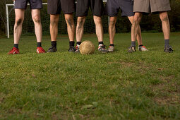 Legs of five young male soccer players, standing in a row