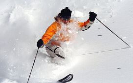Frau beim Skifahren, macht Telemark im Tiefschnee, Stubaital, Österreich
