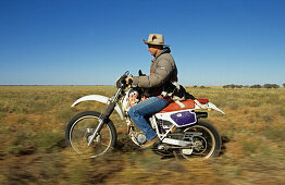 Damien Curr on bike with dog, Ilfracombe, Australien, Queensland, Maltilda Highway, Working dog sitting on motorbike with Damien Curr, Cowboy entertainer