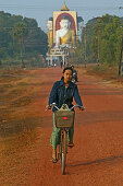 Kyaik-pun Pagode, Bago, Fahrradfaherin, Vier 30 Meter hohe sitzende Buddhafiguren, Cyclist, early morning, Kyaikpun Pagoda is formed by four sitting Buddhas 30 metres high