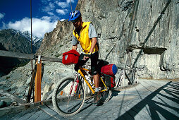 Mountainbiker, Haengebruecke, b. Chalt, Karakorum Highway Hunza Valley, Pakistan