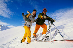 Young couple on slope with skifox and snowscoot, Serfaus, Tyrol, Austria