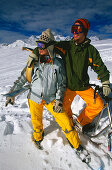 Young couple embracing on slope, holding skifox and snowscoot, Serfaus, Tyrol, Austria