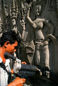 Ein Mann repariert ein Relief, Angkor Wat, Siem Raep, Kambodscha, Asien