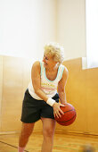 Ältere Frau beim Basketball