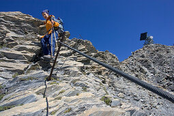 Junge Frau wandert am Klettersteig, Muttler, Samnaun, Val Sinestra, Engadin, Graubuenden, Schweiz