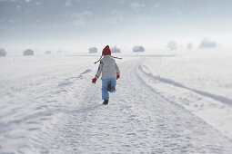 Mädchen 5-6 Jahre, rennt im Schnee