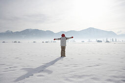 Girl 5-6 Years, arms outstretching in winter scenery