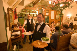 Waiter serving giant Wiener Schnitzel at Restaurant Figlmueller, Vienna, Austria
