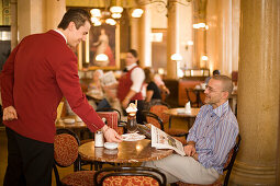 Waiter serving coffee ice at Cafe Central, Vienna, Austria