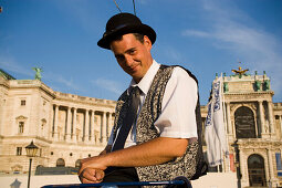 Fiaker coachman looking at camera, in front of Neue Hofburg, Vienna, Austria