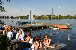 People sitting at Alster Cliff, People sitting in open-air area of Alster Cliff at lake Alster, Hamburg, Germany