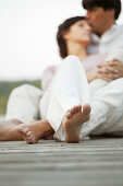 Couple falling in love, sitting on jetty