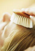 Teenage girlgetting hair care with brush