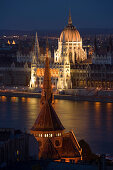 View over Calvinist Church and Danube river to the illuminated Parliament at night, Pest, Budapest, Hungary