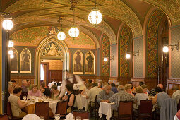People in the Karpatia Restaurant, Waiter attending on guests in the Karpatia Restaurant, Pest, Budapest, Hungary