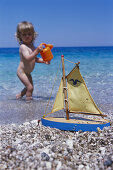 Little girl playing on beach, Karpathos, Dodecanese Islands, Greece