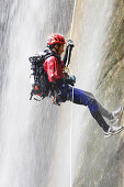 Canyoning, Ein Man seilt in einem Wasserfall ab, Piscia di Gallu, Ospedale, Mittelmeer, Korsika, Frankreich