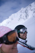 Young couple carrying skis on shoulders, Kuehtai, Tyrol, Austria