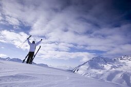 Junger Skifahrer hebt die Arme in die Höhe, Kühtai, Tirol, Österreich