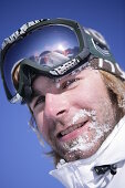 Young man wearing ski googles, portait, Kuehtai, Tyrol, Austria