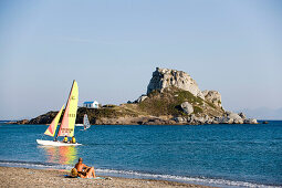 Catamaran in front of Kastri island with capel St. Nicholas, bay of Kefalos, Kefalos, Kos, Greece