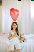 Girl holding red ballon