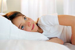 Little girl lying on bed, portrait