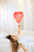 Girl holding red ballon