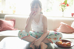 Girl sitting on table,eating an apple