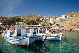 Boats at bank of the peopled Super Paradise Beach, knowing as a centrum of gays and nudism, Psarou, Mykonos, Greece