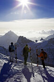 Drei Skifahrer bewundern die Aussicht vom Titlis auf einige Berggipfel. Titlis, Zentralschweiz, Schweiz, Alpen, Europa, MR