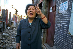 Abriss, demolitian Hongkou,Last residents of a demolished quarter, refusing resettlement, letzte Bewohner eines Abrissviertels, die sich der Umsiedlung widersetzen, redevelopment area, Abrissgebiet, living amongst demolished  houses, slum, old lady blames