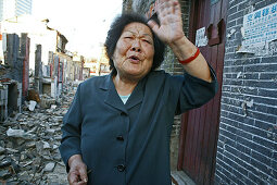 Abriss, demolitian Hongkou,Last residents of a demolished quarter, refusing resettlement, letzte Bewohner eines Abrissviertels, die sich der Umsiedlung widersetzen, redevelopment area, Abrissgebiet, living amongst demolished houses, slum, old lady blames 