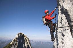Young female climber on Donnerkogel fixed rope route, Dachstein Mountain, Austria