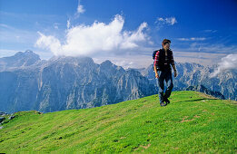 Frau wandert auf einer alpinen Wiese, auf dem Gipfel des Debela Pec, Triglav Nationalpark, Julische Alpen, im Hintergrund der Triglav Gipfel, Slowenien, Alpen.MR