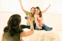 Teenage girl (14-16) taking photo of two other girls