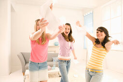 Teenage girls (14-16) throwing papers through the room