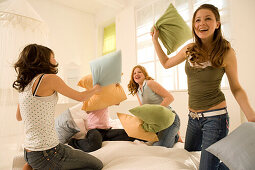 Teenage girls (14-16) having pillow fight