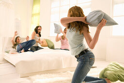 Teenage girls (14-16) having pillow fight