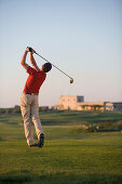 Man driving golf ball, rear view, Apulia, Italy