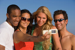 Four young people taking picture with camera phone, Apulia, Italy