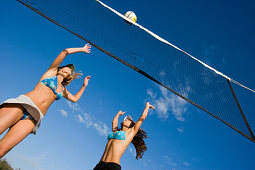 Two young woman playing beach volleyball, Apulia, Italy